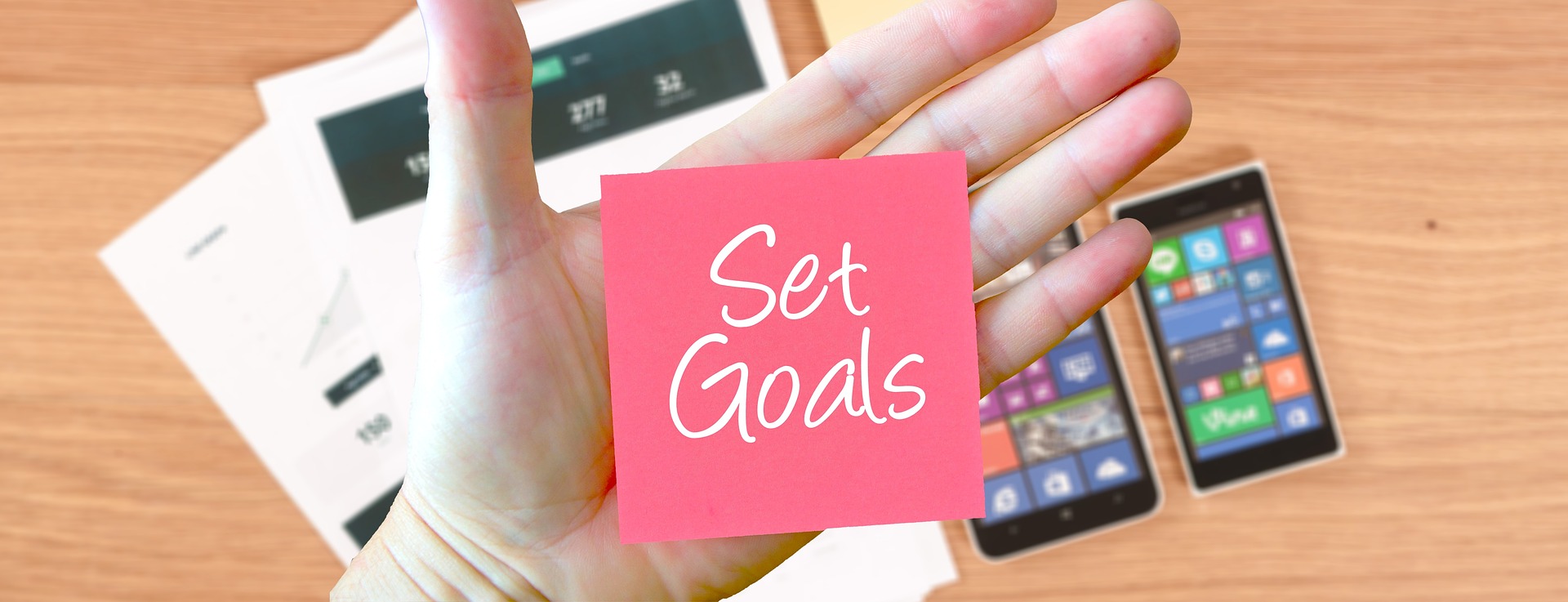 hand with post it note saying Set Goals